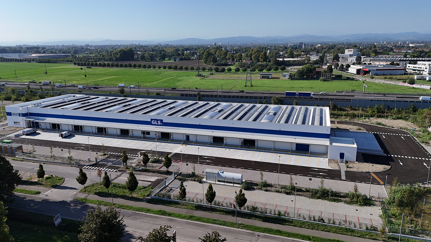 Vista aerea della nuova sede GLS di Reggio Emilia, un moderno hub logistico di oltre 20.000 metri quadri dotato di impianti automatizzati, piazzali e aree di carico. La struttura, strategicamente posizionata vicino al casello autostradale, è progettata per garantire efficienza e sostenibilità.
