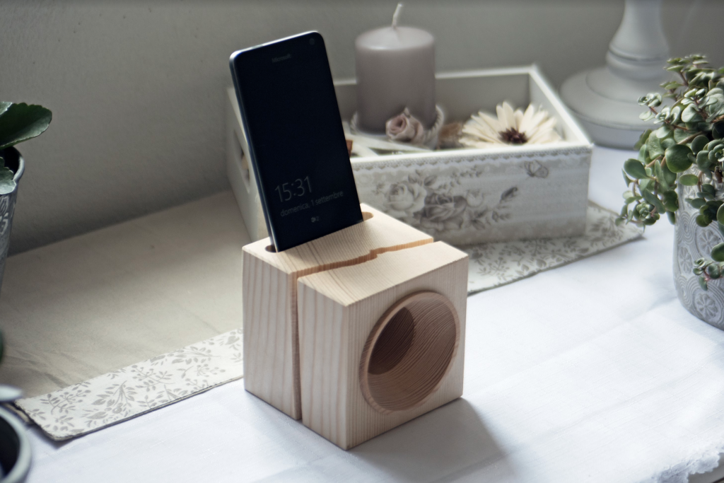 VAIA Cube – Amplificatore naturale in legno Amplificatore naturale VAIA Cube in legno chiaro, posizionato su un tavolo con uno smartphone inserito. Un design minimalista e sostenibile che unisce artigianato e tecnologia